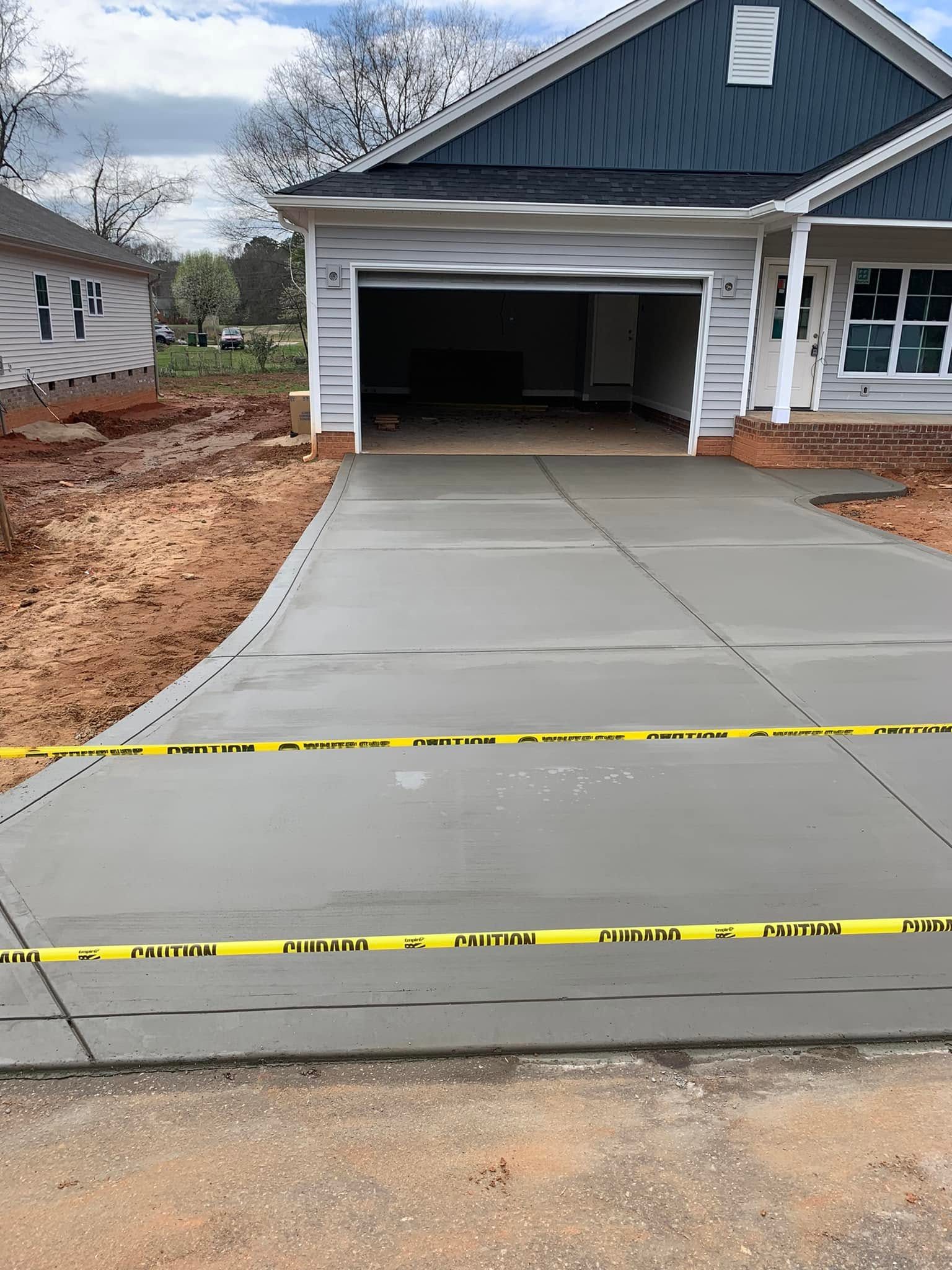 Finished concrete driveway leading to a garage